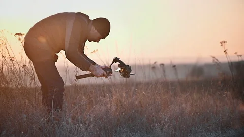 View of a photographer filming using a camera with a stabiliser in the nature at Stock Footage 235283159