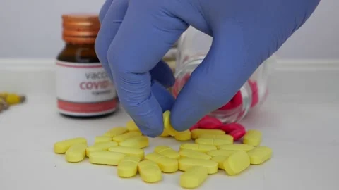 View of picking one yellow tablet from bunch of tablets with glass bottle aro Stock Footage 147697345