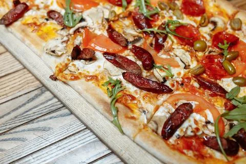 A view of a pizza pie with several meat toppings. Stock Photos