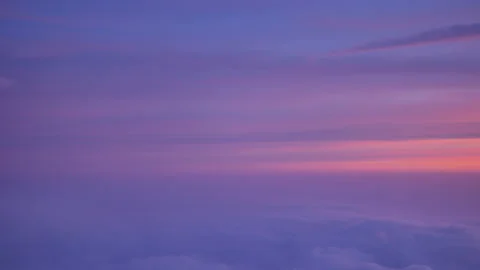 View from the plane above the clouds on scenic pink and lilac sky at sunset - 4K Stock Footage 195933443
