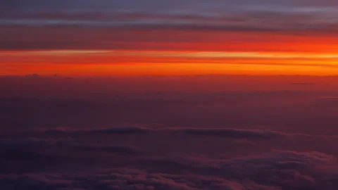 View from the plane above purple clouds on scenic orange sky at sunset - 4K Stock Footage 195933313
