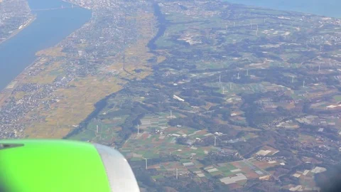 View of plane engine and land while airplane is landing in Tokyo, Japan. Stock Footage 77090834