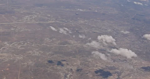 The view from the plane of fluffy clouds in desert mountains from an airplane Stock Footage 162973172