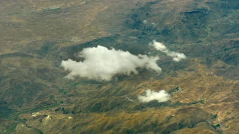 View from plane flying above clouds over green mountains range. Beautiful top Stock Footage 221707117
