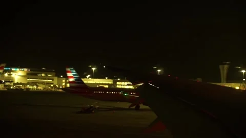 View from plane going past American Airlines plane at night Stock Footage 233897771