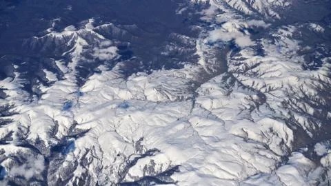 View from plane to snow capped peaks of Caucasus Mountains Stock Photos