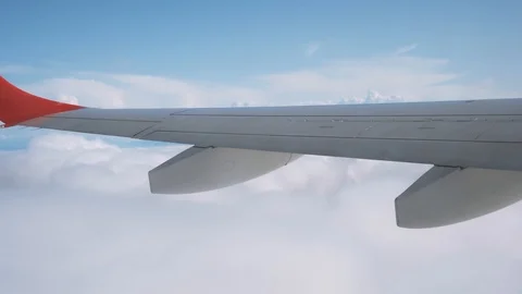 View from the plane through the window to incredibly beautiful clouds and sky 4K Stock Footage 121436904