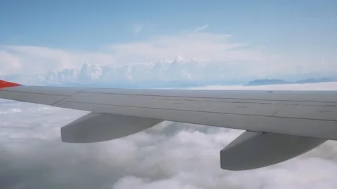 View from the plane through the window to incredibly beautiful clouds and sky 4K Stock Footage 121436962
