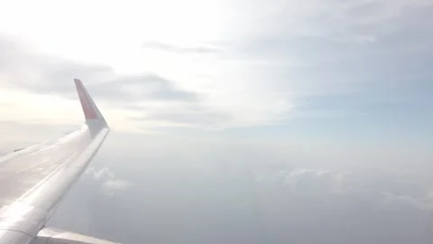 View from plane window of airplane's engine while airplane flying over sky .. Stock Footage 337929516