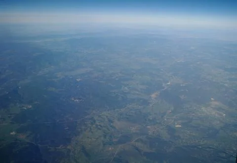 View from the plane window to the clouds and the earth Stock Photos