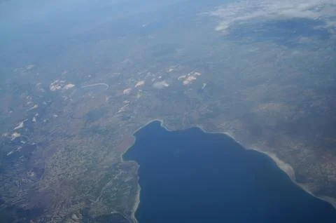 View from the plane window to the clouds and the earth Stock Photos