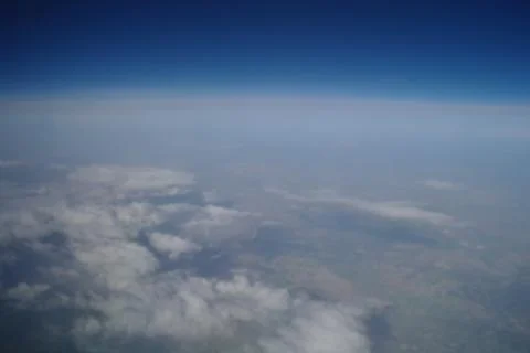 View from the plane window to the clouds and the earth Stock Photos