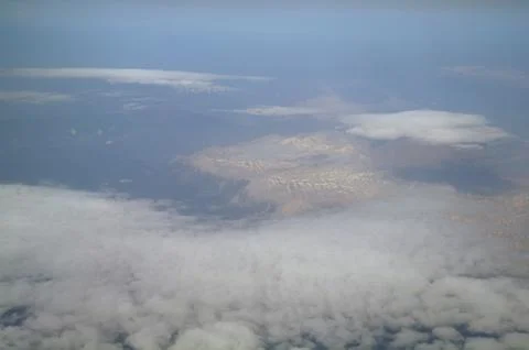 View from the plane window to the clouds and the earth Stock Photos