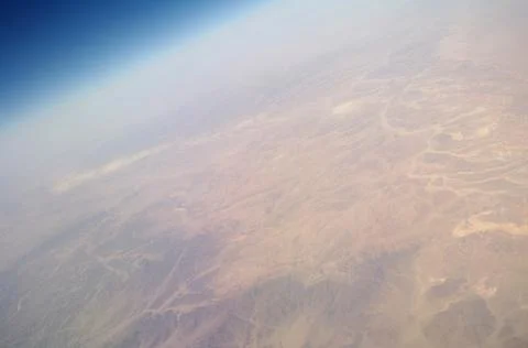 View from the plane window to the clouds and the earth Stock Photos