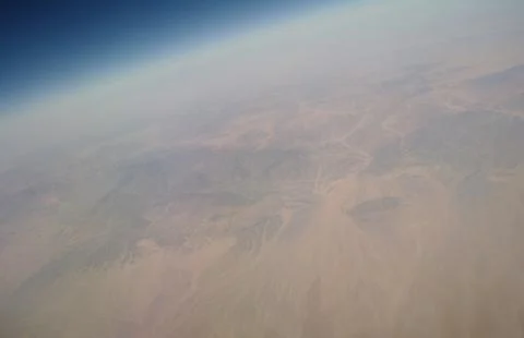 View from the plane window to the clouds and the earth Stock Photos