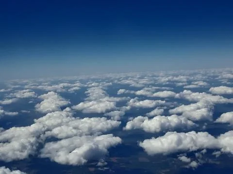 View from plane window of cloudy blue sky 스톡 사진