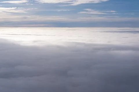 The view from the plane window of dense curly clouds and the blue stratosph.. Stock Photos