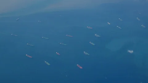 The view from the plane window is flying over the ocean. Many ships, cargo sh Stock Footage 128730337