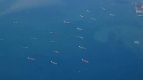 The view from the plane window is flying over the ocean. Many ships, cargo sh Stock Footage 128730461