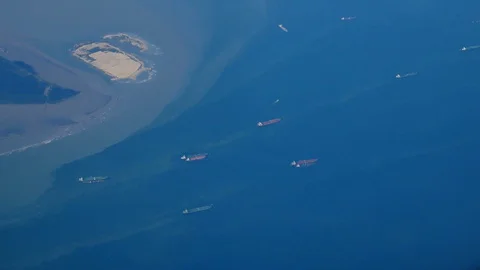 The view from the plane window is flying over the ocean. Many ships, cargo sh Stock Footage 128730975