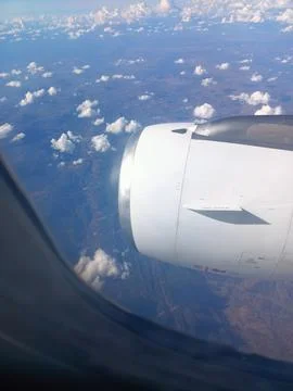 View from the plane window to the ground, clouds and blue sky Stock Photos