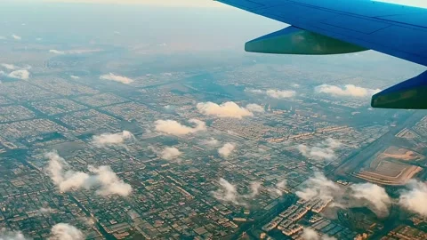 View from a plane window. Large city and white clouds below. Stock Footage 266673369