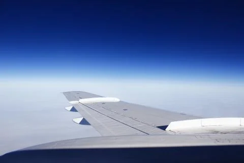 View from the plane into the window. multicolored sky above the wing. fly on  Stock Photos