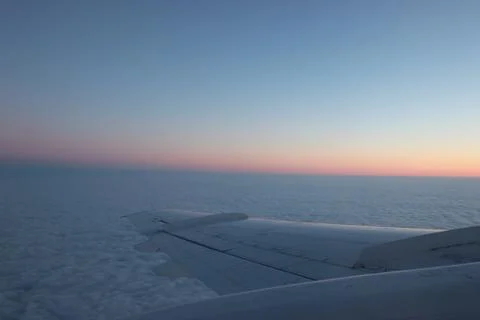 View from the plane into the window. multicolored sky above the wing. fly on  Foto stock