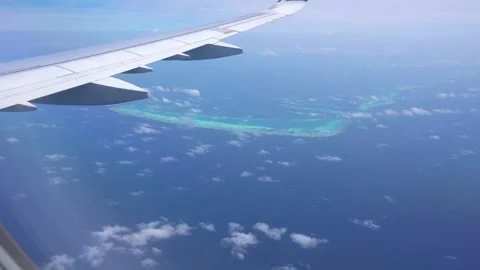 View from the plane window of the ocean and atoll Video stock 285561840