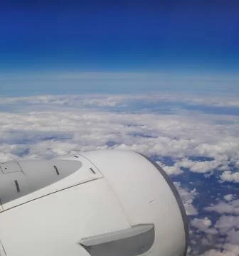 View from plane window over jet engine with white clouds Foto stock