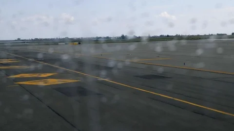 View from the plane window with rain drops on airport runway while plane moving Stock Footage 106783061