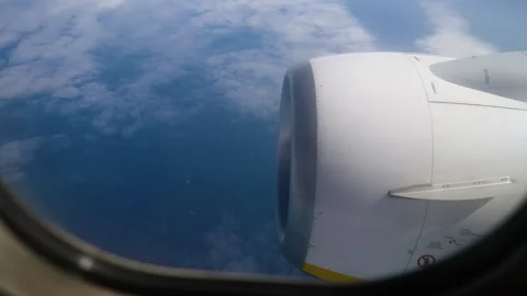 View From Plane Window Showcasing Airplane Engine Against Backdrop of Fluffy Stock Footage 301913434
