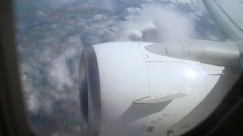 View From Plane Window Showcasing Engine and Clouds During Daytime Flight Over Stock Footage 301913617
