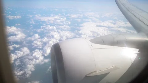 View From Plane Window Showcasing Fluffy Clouds and Aircraft Engine During Stock Footage 306013599