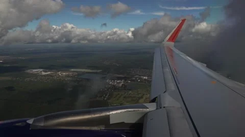 View from the plane window on the wing and Cumulus clouds. A plane flies through Stock Footage 143668817