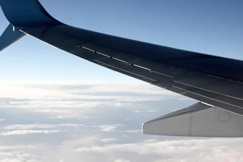 View of the plane wing and clouds from the plane window Stock Photos