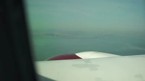 View of plane wing and engine with San Francisco skyscrapers in distance Stock Footage 236351813