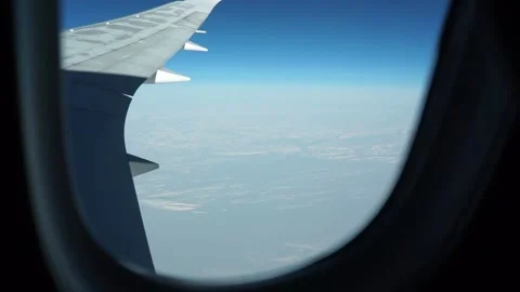 View from plane wing: horizon separates white snow and blue sky Stock Footage 235650485