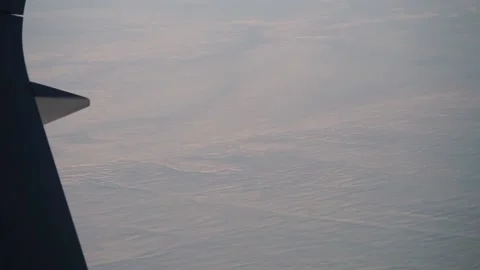 View from plane wing: wind swept lines and crenulations in snow Stock Footage 235650468