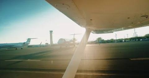 View of planes on runway from inside small plane at sunrise Stock Footage 75920724