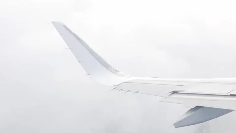 View of plane's wing over blue sky while make a turn with white fluffy clou.. Stock Footage 296089497