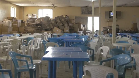 View of plastic chairs and tables and a dozen of carton packagings Video stock 108476983