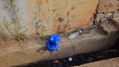 View of plastic waste along roadside drainage showing pollution and environ.. Stock Footage 336042659