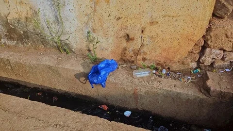 View of plastic waste along roadside drainage showing pollution and environ.. Stock Footage 336042711