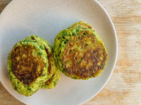 View on plate with two piles of crispy pancakes with spinach Stock Photos