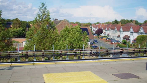 View of a platform and suburban scenery through the doors of a train Stockbeeldmateriaal 319725060