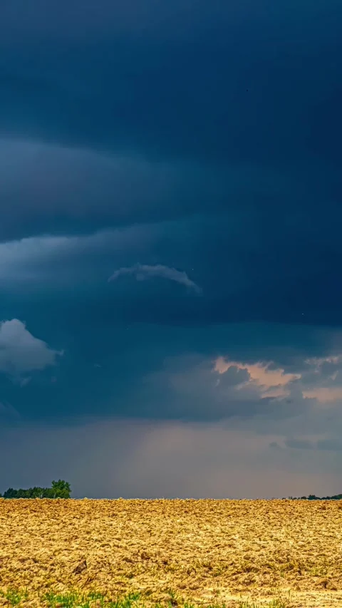 View of a plowed field under a dark stormy sky in Latvia. Stock Footage 339951318
