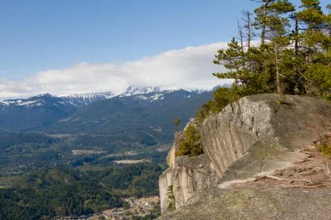 View point from cliff above valley with mountains and clouds. Stock Photos