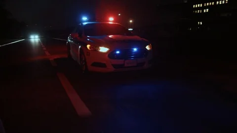 View of police car driving in the street with lights and siren. Emergency Stock Footage