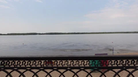 View of the pond and sandy beach through the railings of the fence. Rest Stock Footage 194357028